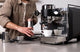 Prosumer espresso machine pulling a shot on a modern kitchen counter