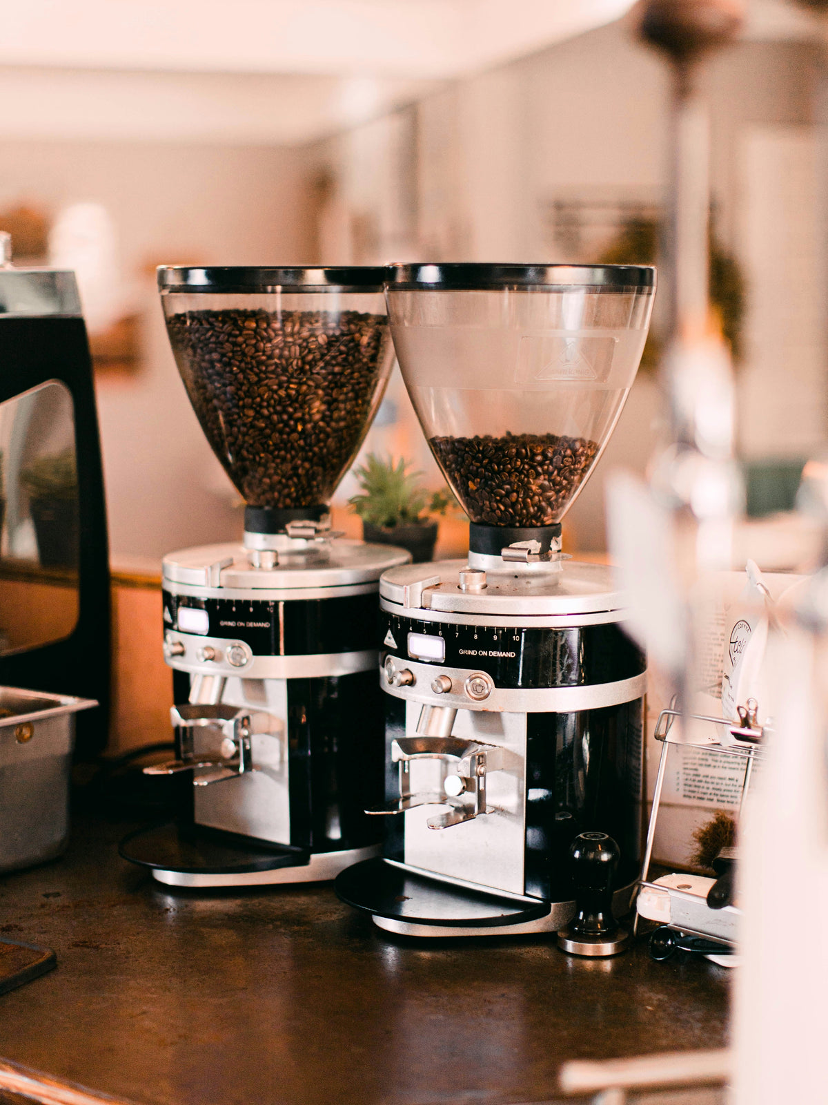 2 coffee grinders with beans in the hopper