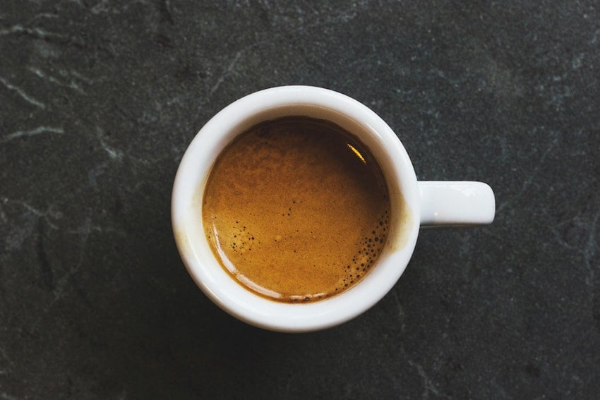 Overhead view of a coffee cup filled with a shot of espresso resting on a table surface - Seattle Coffee Gear